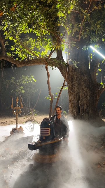 Saheb in meditation beside a Shivling at night amid sacred smoke